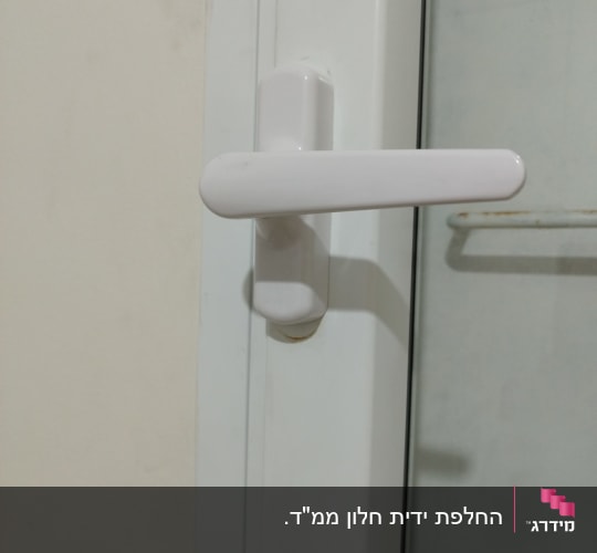 ידית חלון לבנה על מסגרת זכוכית
